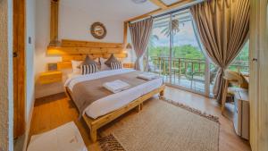 ein Schlafzimmer mit einem großen Bett und einem Balkon in der Unterkunft WaterCloud Mathiveri in Insel Mathiveri