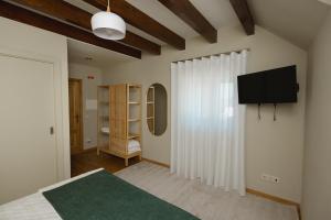 a bedroom with a bed and a television on a wall at KV Residences 