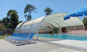 a group of blue chairs sitting next to a swimming pool at FH Mobile home Camping des Viviers in Lège-Cap-Ferret