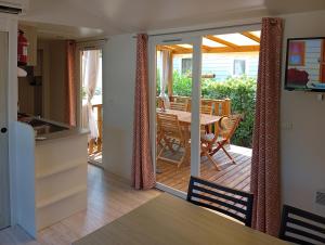 a kitchen and dining room with a table on a deck at FH Mobile home Camping des Viviers in Lège-Cap-Ferret