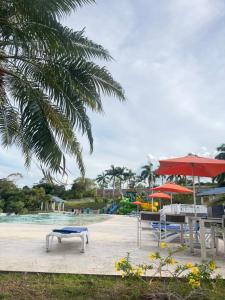a park with a bench and a table and umbrella at Playa dorodo in La Chorrera
