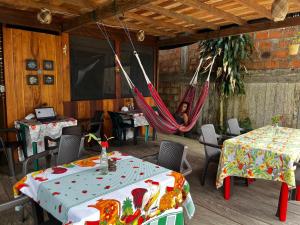 a woman is sitting in a hammock in a restaurant at Renacer in Termales - agua caliente - nuqui
