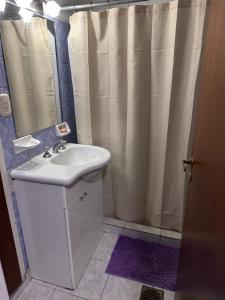 a bathroom with a sink and a shower curtain at French in Tres Arroyos