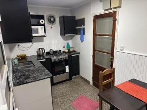 a small kitchen with a stove and a microwave at French in Tres Arroyos