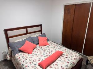 a bedroom with a bed with red and gray pillows at French in Tres Arroyos