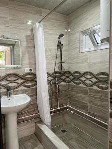 a bathroom with a sink and a shower at Lentexi Inn in Lentekhi