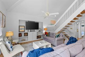 a living room with a couch and a tv at 735 Spinnaker Beach House in Seabrook Island