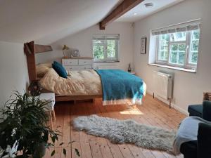 a bedroom with a bed with a blue blanket and a rug at Offa's Hideaway - Wye Valley in Newland +13 photos