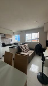 a living room with a couch and a kitchen at Flat Eufrates 205 in Olinda