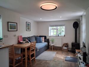 a living room with a blue couch and a table at Offa's Hideaway - Wye Valley in Newland