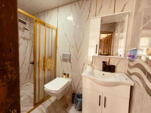 a white bathroom with a sink and a toilet at Fazilet Hanım Konağı in Şahinbey