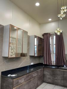 a kitchen with wooden cabinets and a black counter top at Sukoon Farms in Greater Noida
