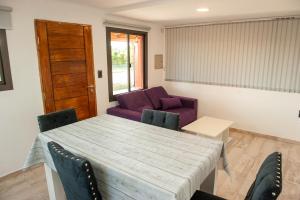 a living room with a table and a purple couch at Cabañas Morita Mia in San Rafael