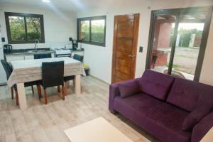 a living room with a purple couch and a table at Cabañas Morita Mia in San Rafael