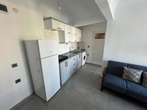 a kitchen with a white refrigerator and a blue couch at Raif Arda Apart in Marmara +12 photos