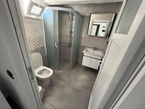 a bathroom with a shower and a toilet and a sink at Raif Arda Apart in Marmara