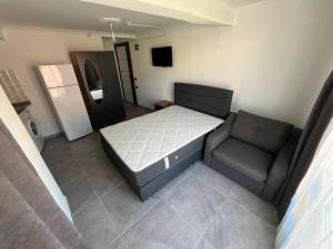 a small bedroom with a bed and a chair at Raif Arda Apart in Marmara