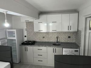 a kitchen with white cabinets and a sink at Raif Arda Apart in Marmara