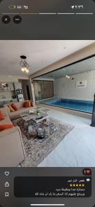 a living room with a couch and a swimming pool at شاليهات الورد الفندقية in Ash Shuqayq