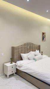 a bedroom with a large bed with white pillows at شاليهات الورد الفندقية in Ash Shuqayq