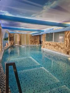 a large swimming pool with blue water at Faraon apartmani Beograd in Belgrade