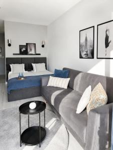 a living room with a couch and a bed at Kairos Apartments - Lothus - darmowy garaż podziemny, ścisłe centrum in Gliwice +15 photos