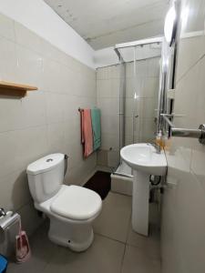 a white bathroom with a toilet and a sink at ponta gato residence in Tarrafal