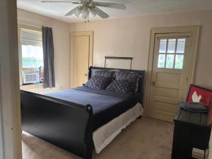 a black bed in a bedroom with a ceiling fan at Updated cozy in central Cleveland in Cleveland