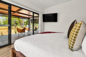 a bedroom with a white bed and a sliding glass door at Ka'ana Resort & Spa in San Ignacio