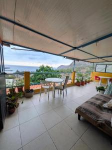 a room with a table and chairs on a balcony at ponta gato residence in Tarrafal