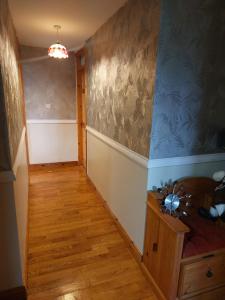 a hallway with a room with blue walls and wooden floors at Levally hs mountrivers doonbeg co clare in Kilrush