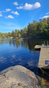 a view of a lake with a wooden dock at Cozy cottage on Värmdö in Djurhamn