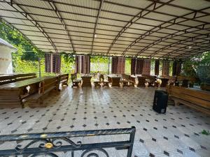 a large empty room with wooden benches and tables at Датка in Arslanbob