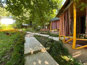 a walkway in front of a house with a tree at Датка in Arslanbob +13 photos
