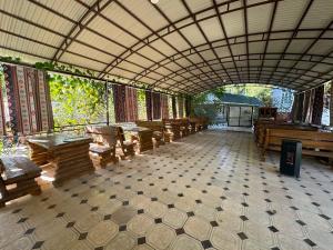 a large room with benches and tables in a building at Датка in Arslanbob