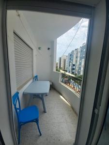 a room with a table and a blue chair and a window at galaxy home in Nabeul