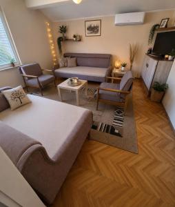 a living room with a bed and a couch at Dvosoban stan in Užice