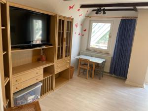 a living room with a flat screen tv and a table at To Huus bei Hanne 