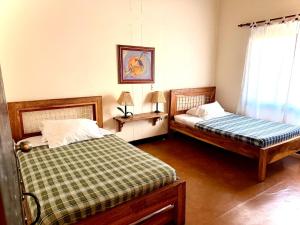 a bedroom with two beds and a window at Fincas Panaca Herreria 23 in Quimbaya