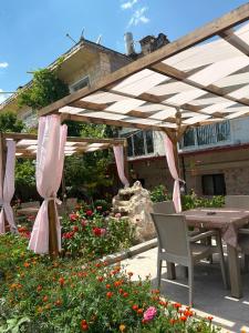 a wooden pergola with a table and chairs in a garden at ÖzkanHouse in Ürgüp +13 photos