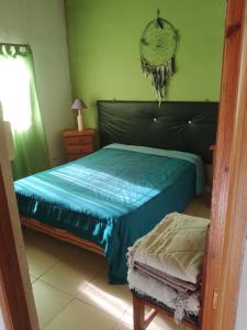 a bedroom with a bed with blue sheets and a mirror at casa en toninas in Las Toninas