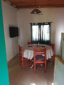 a dining room with a table and chairs and a television at casa en toninas in Las Toninas