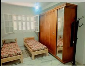 a small room with two beds and a cabinet at Dar Khuwayra in El Haouaria