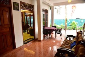 a living room with a table and chairs and a balcony at Summer Lanka Surf House in Hikkaduwa