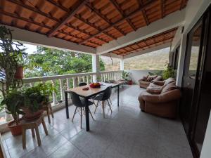 a screened in porch with a table and a couch at Ponta Gato Residence in Tarrafal