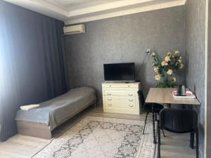 a small bedroom with a bed and a desk with a computer at Dan plus in Aktobe +29 photos