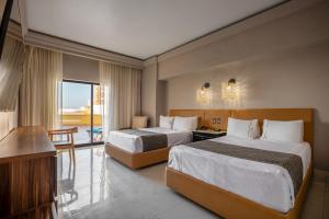a hotel room with two beds and a television at Royal Villas Resort in Mazatlán
