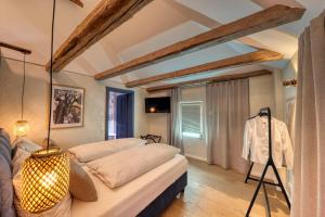 a bedroom with two beds and a tv at Casa Di Pietra in Maria Saal