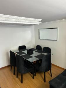 a dining room with a black table and black chairs at Luxurious Stay con 3 habitaciones in Bello