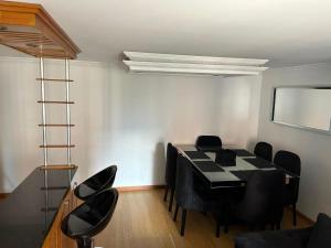 a dining room with a table and black chairs at Luxurious Stay con 3 habitaciones in Bello
